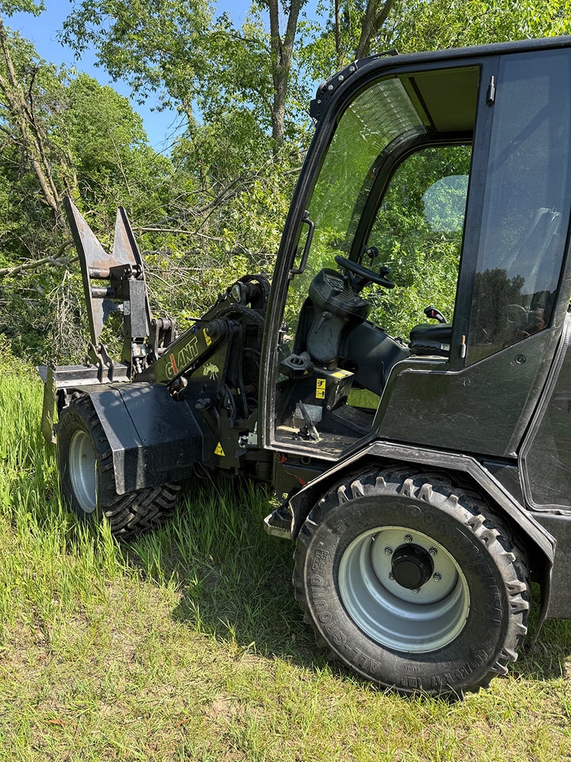 Image of the All American Tree Service wheel loader clearing brush from a recent storm.